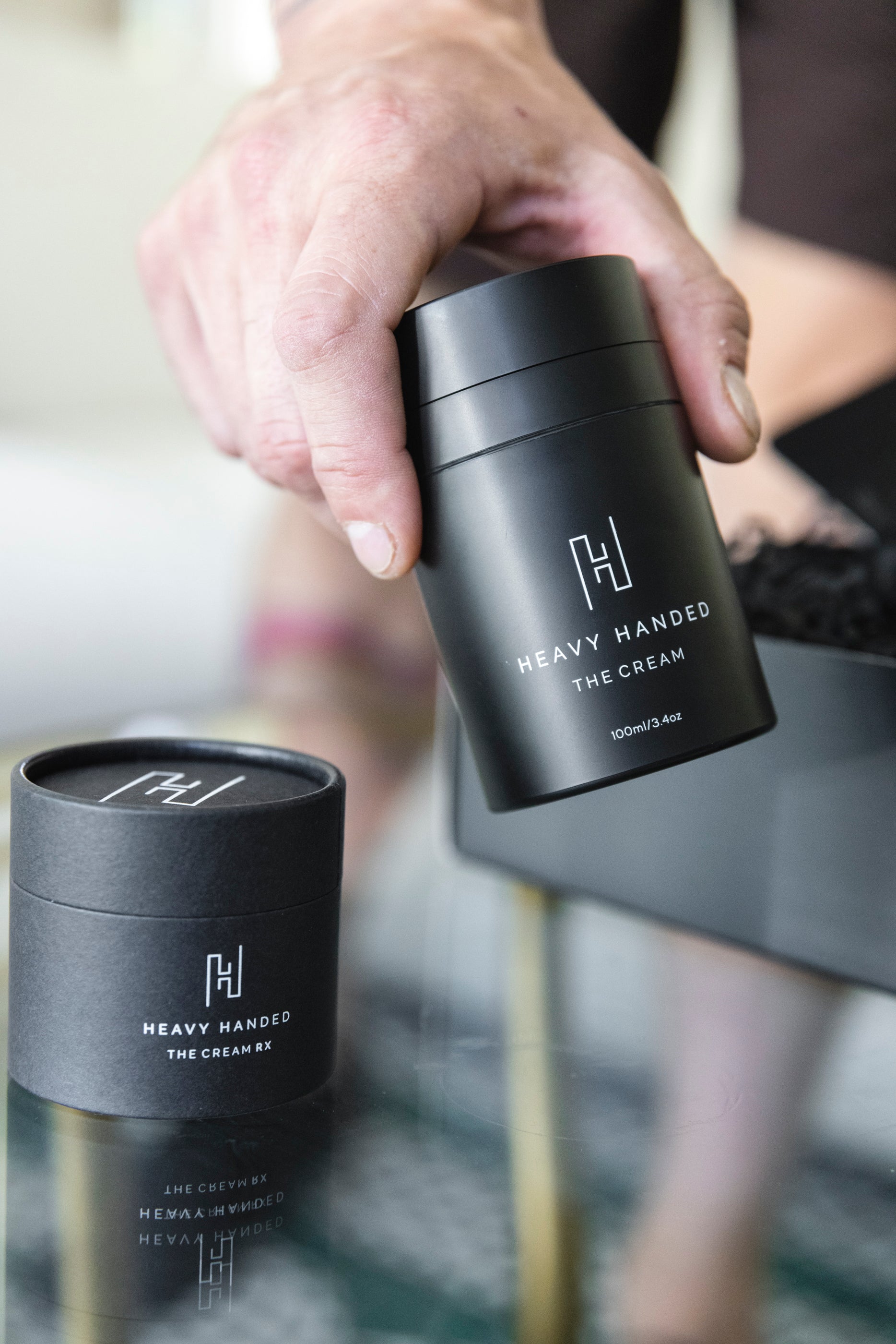 Athlete's hand holding Heavy Handed Skin Cream, a non-greasy hand cream for athletes and CrossFit enthusiasts.